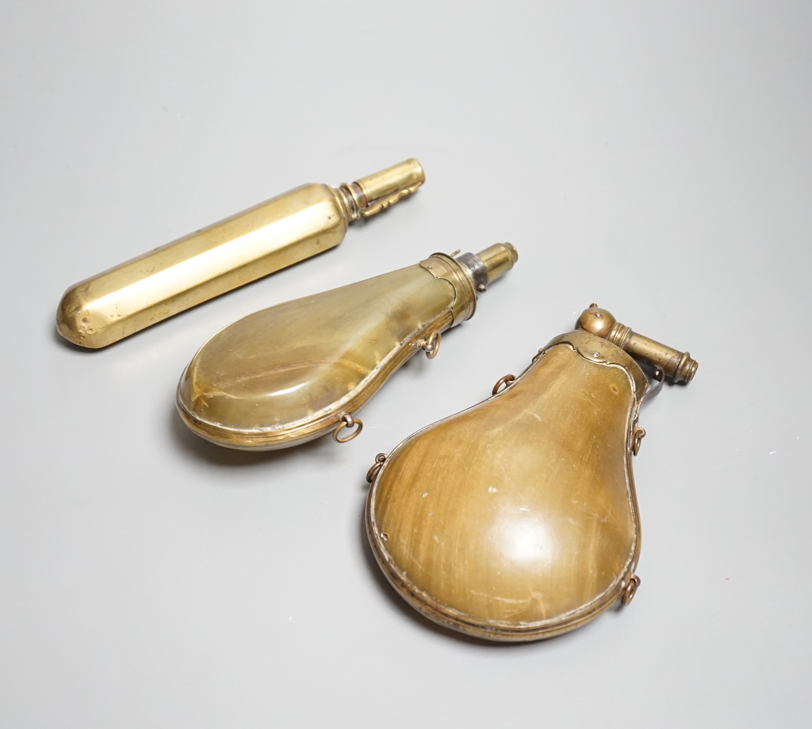 Two French lant horn powder flasks with brass mounts c.1800, one with graduated folding charger, and another unusual octagonal brass powder flask. Maximum 20cms